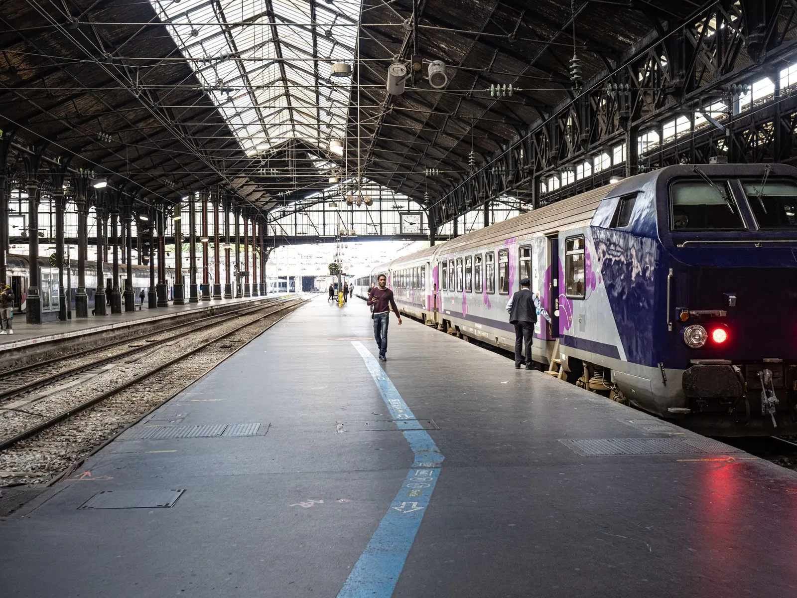 Quai d'une gare parisienne sous verrière, train à quai